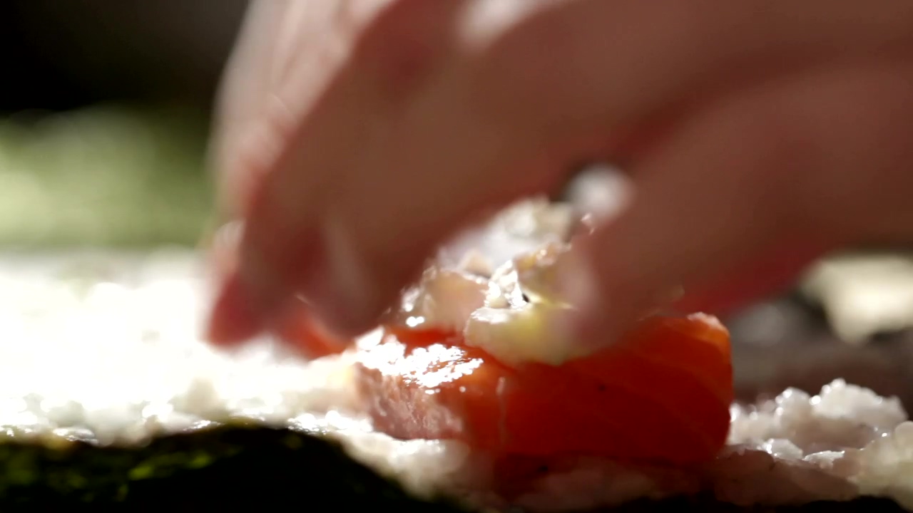 Adding fish and cheese to a sushi roll, fish, sushi, and cheese