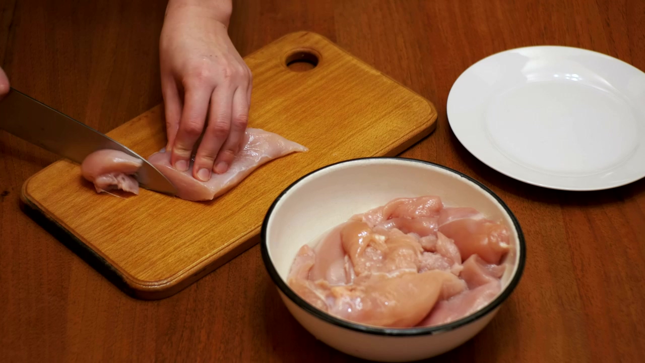 Person cutting chicken meat in kitchen, food, food preparation, meat, and chicken