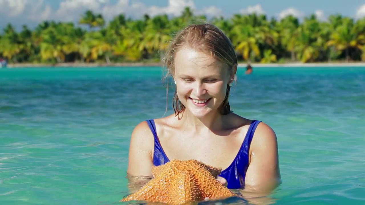 Smiling woman holding a starfish, woman, nature, international womens day, and fish
