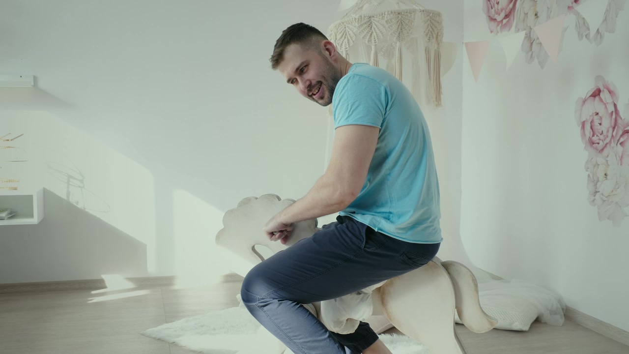 Young man riding a toy horse, man, indoor, toy, and horse